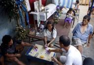 Residents play cards near a coffin during a funeral wake in Paranaque city, Metro Manila, Philippines April 23, 2015. When paying your final respects for a relative or friend, the last thing you might expect to see at the wake is people placing bets on a card game or bingo. Not in the Philippines. Filipinos, like many Asians, love their gambling. But making wagers on games such as "sakla", the local version of Spanish tarot cards, is particularly common at wakes because the family of the deceased gets a share of the winnings to help cover funeral expenses. Authorities have sought to regulate betting but illegal games persist, with men and women, rich and poor, betting on anything from cockfighting to the Basque hard-rubber ball game of jai-alai, basketball to spider races. Many told Reuters photographer Erik De Castro that gambling is only an entertaining diversion in a country where two-fifths of the population live on $2 a day. But he found that some gamble every day. Casino security personnel told of customers begging to be banned from the premises, while a financier who lends gamblers money at high interest described the dozens of vehicles and wads of land titles given as collateral by those hoping lady luck would bring them riches. REUTERS/Erik De Castro TPX IMAGES OF THE DAY PICTURE 18 OF 29 FOR WIDER IMAGE STORY "HIGH STAKES IN MANILA". SEARCH "BINGO ERIK" FOR ALL IMAGES.