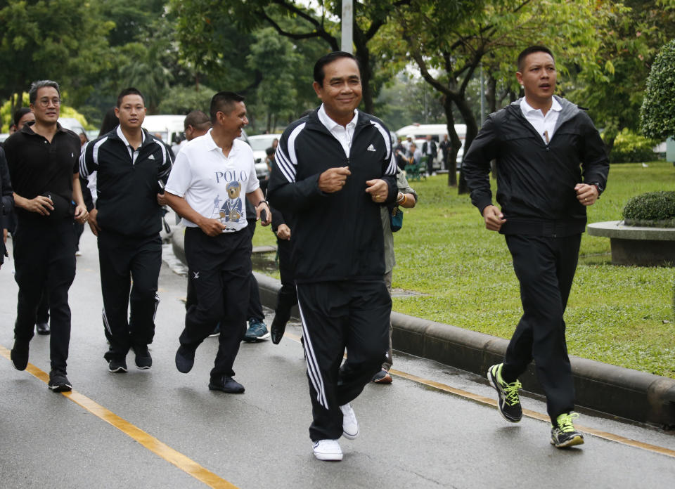 In this Oct. 5, 2018, photo, Thai Prime Minister Prayuth Chan-ocha, center, jogs in Lumpini park in central Bangkok, Thailand. Prayuth became prime minister in a very Thai way: He led a military coup. Now after five years of running Thailand with absolute power, he’s seeking to hold on to the top job through the ballot box. (AP Photo/Sakchai Lalit)