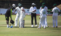 A medic attends to Zimbabwe batsman Regis Chakabva, left, after he was injured his finger, during the second test cricket match between Zimbabwe and Pakistan at Harare Sports Club, Sunday, May, 9, 2021.(AP Photo/Tsvangirayi Mukwazhi)