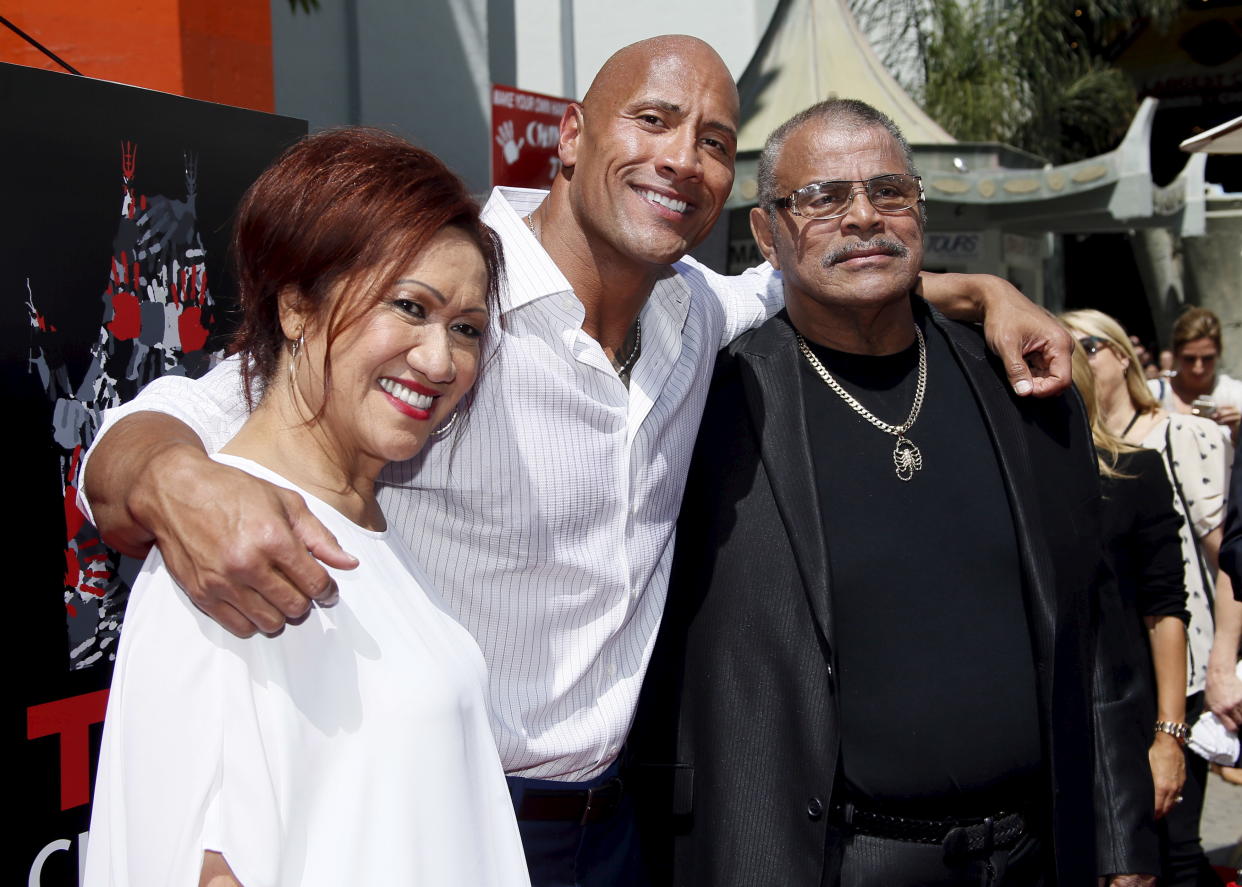 Actor Dwayne "The Rock" Johnson (C) poses with his mother Ata Johnson (L) and father Rocky Johnson (R) during his hand and footprints ceremony in the forecourt of the TCL Chinese Theatre in celebration of his new movie "San Andreas," in Hollywood, California May 19, 2015. REUTERS/Danny Moloshok