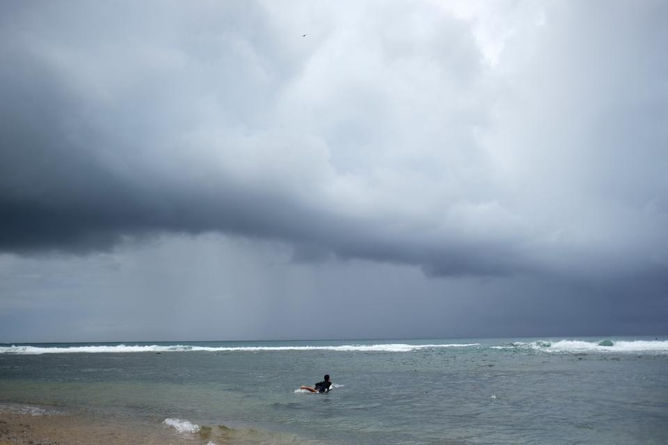 A surfer enters the water as Tropical Storm Dorian approaches in Patillas, Puerto Rico August 28, 2019.