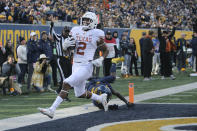 Texas running back Roschon Johnson (2) scores a touchdown ahead of West Virginia safety Alonzo Addae (4) second the first half of an NCAA college football game in Morgantown, W.Va., Saturday, Nov. 20, 2021. (AP Photo/Kathleen Batten)