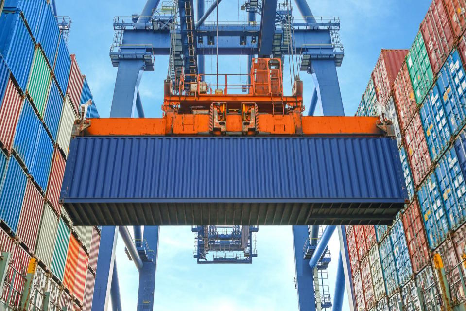 A shore crane stacking containers at a shipping terminal.