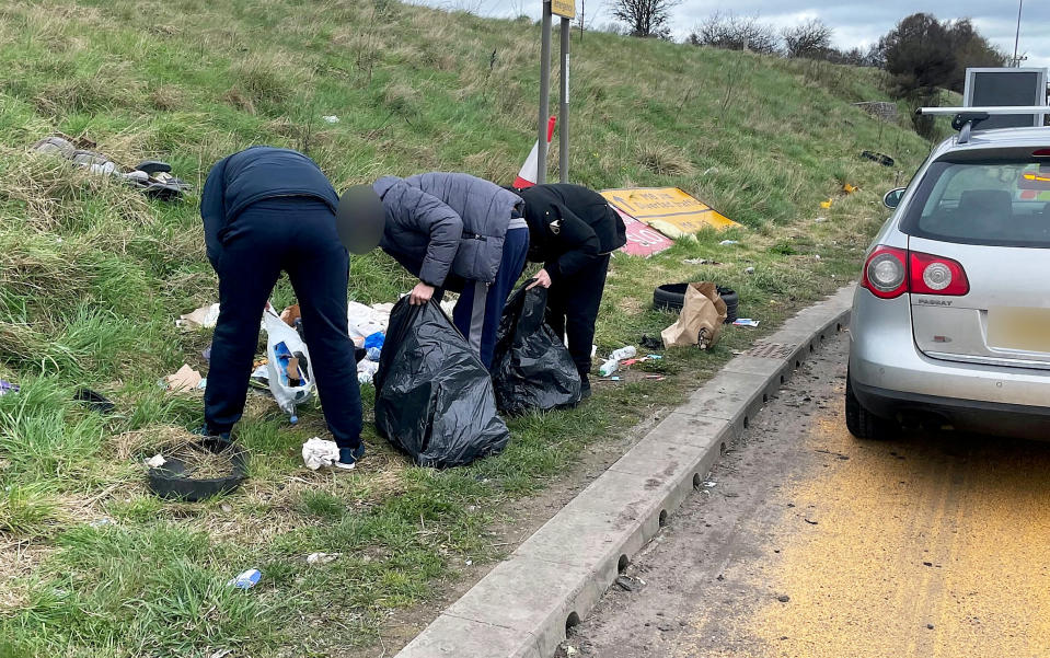 The group picking up the rubbish that they dumped on the side of the M6 motorway in Staffordshire.  See SWNS story SWMDrubbish.  A group of males were caught by eagle eyed Highways CCTV camera operators, dumping rubbish from their VW Passat on the M6 motorway between junctions 12-13 in Staffordshire.  CMPG officers intercepted the vehicle further up the motorway between junctions 14-15 where they escorted the group back to the dumping site and made them clear the rubbish up themselves.