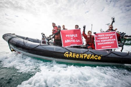 Greenpeace activists hold banners during a protest next to Statoil's Songa Enabler oil rig in the Barents sea, Norway, July 21, 2017. Will Rose/Greenpeace/Handout via Reuters