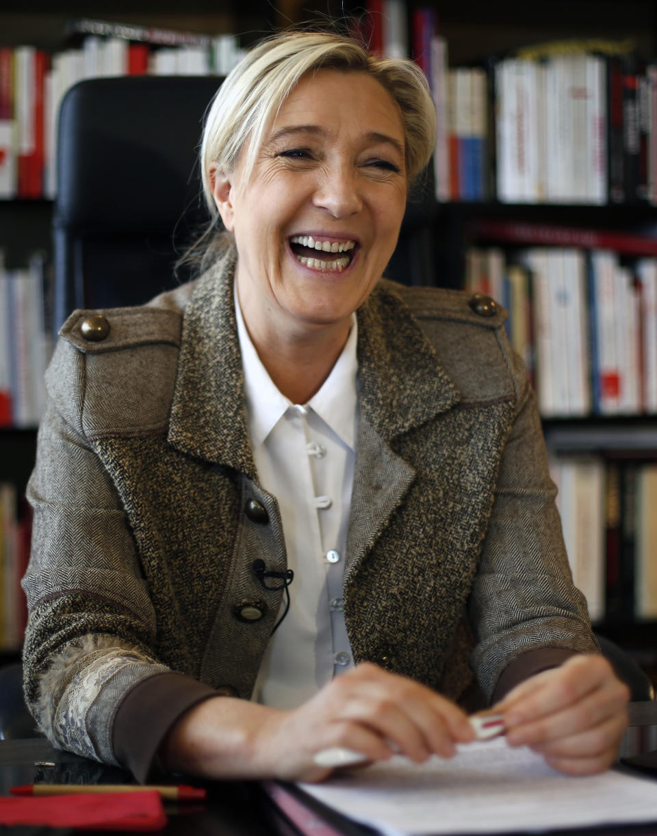 National Front leader Marine Le Pen laughs during an interview with the Associated Press at the party headquarters in Nanterre outside Paris, Monday, March 3, 2014. The leader of France’s far-right National Front is looking to apply some basic principles of her anti-immigrant party in towns where it is victorious in municipal elections this month, like refusing precious public funds for religious associations. A leading euro-skeptic, Le Pen is also looking to boost her party’s strength in European Parliament elections in May. (AP Photo/Jerome Delay)
