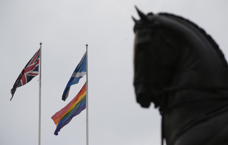 The rainbow flag, bottom right, a symbol of the lesbian, gay, bisexual, and transgender community, flies alongside the British, left, and the Scottish flag over the British government's Scotland Office building, in central London, Friday, March 28, 2014, to mark the start of same-sex weddings in the UK from Saturday March 29, 2014. The British government has ordered rainbow flags to be flown over two prominent government buildings to mark the country’s first same-sex weddings, ahead of the law taking effect on Saturday. It marks a profound shift in attitudes in a country that little more than a decade ago had a law on the books banning the "promotion" of homosexuality. (AP Photo/Lefteris Pitarakis)