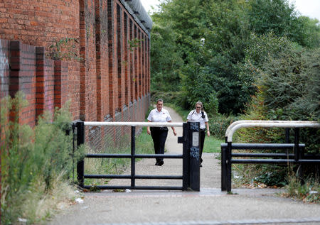 Prison workers walk outside the walls of HMP Birmingham after the British government took over its running from G4S, in Birmingham, Britain August 20, 2018. REUTERS/Darren Staples