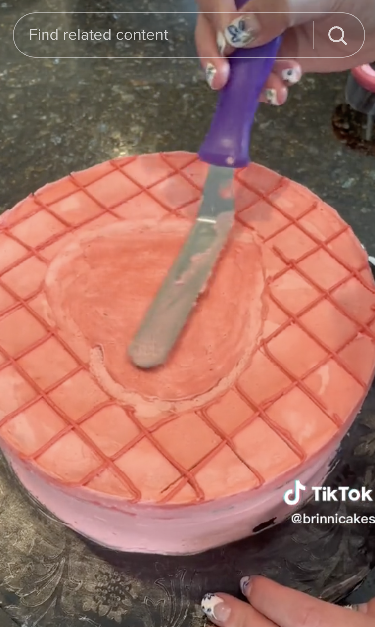 Brinni Cakes' TikTok using an offset spatula to spread icing