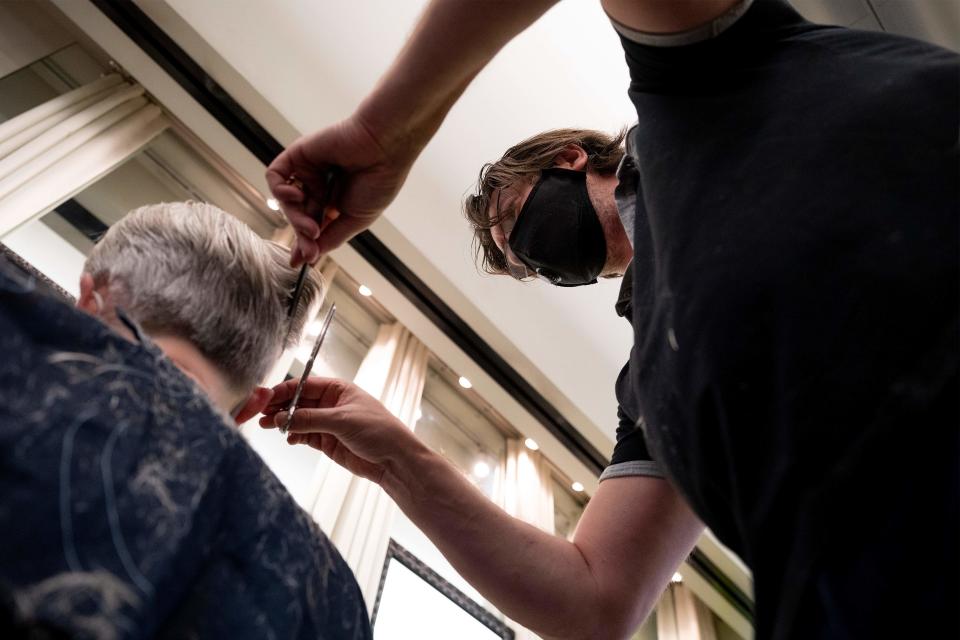 Owner of Saint Germain Hair Salon in Washington, DC, Franck Rihouey wears a mask as he trims Joe PouxÕs hair on May 29, 2020, as the District's phase 1 reopening plan begins. - Friday marks the beginning of phase one for the District of Columbia following the stay at home orders from the COVID-19 pandemic. (Photo by JIM WATSON / AFP) (Photo by JIM WATSON/AFP via Getty Images)