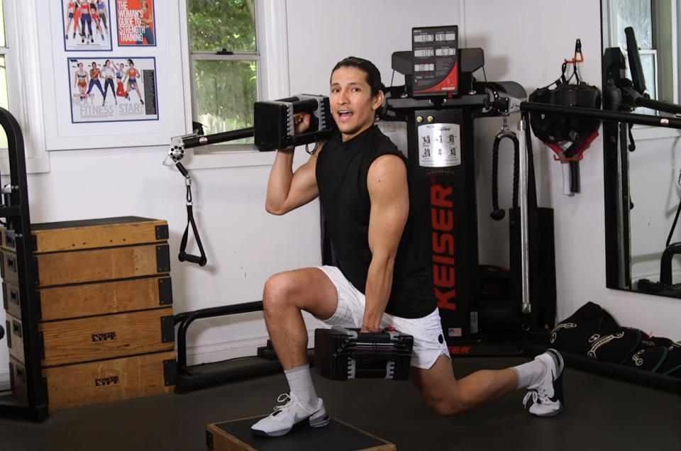 Danny doing squats while carrying weights in a gym