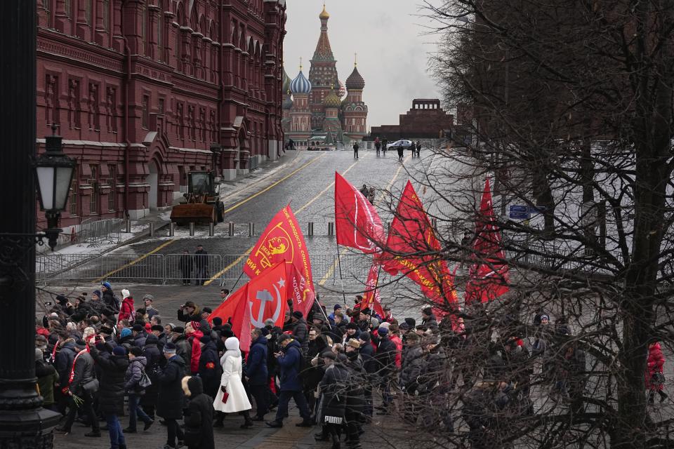 Communist's' party supporters with Red flags walk after a wreath-laying ceremony at the Tomb of the Unknown Soldier near the Kremlin Wall attending commemorations marking the 80th anniversary of the Soviet victory in the battle of Stalingrad in Moscow, Russia, Thursday, Feb. 2, 2023. The battle of Stalingrad turned the tide of World War II and is regarded as the bloodiest battle in history, with the death toll for soldiers and civilians estimated at about 2 millions. (AP Photo/Alexander Zemlianichenko)