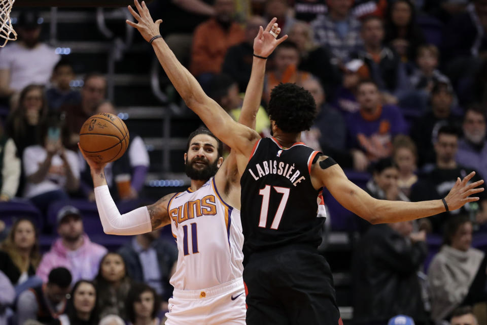 Phoenix Suns guard Ricky Rubio (11) passes around Portland Trail Blazers forward Skal Labissiere (17) during the first half of an NBA basketball game, Monday, Dec. 16, 2019, in Phoenix. (AP Photo/Matt York)