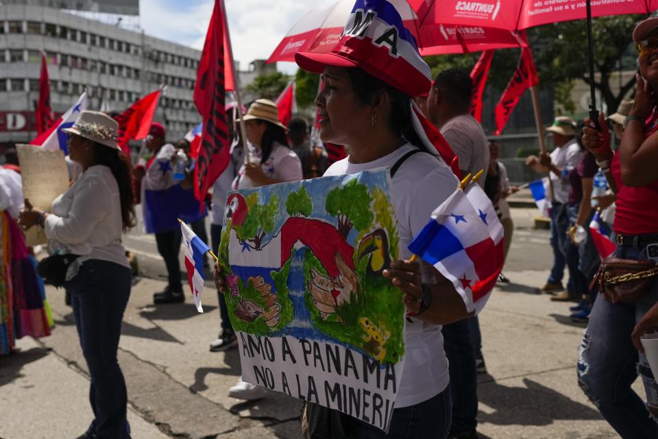 A woman holds a banner with a message sthat read in Spanish: "I love Panama, Not mining", during a protest against a mining contract between the Panamanian government and the Canadian mining company First Quantum, in Panama City, Friday, Nov. 3, 2023. (AP Photo/Arnulfo Franco)