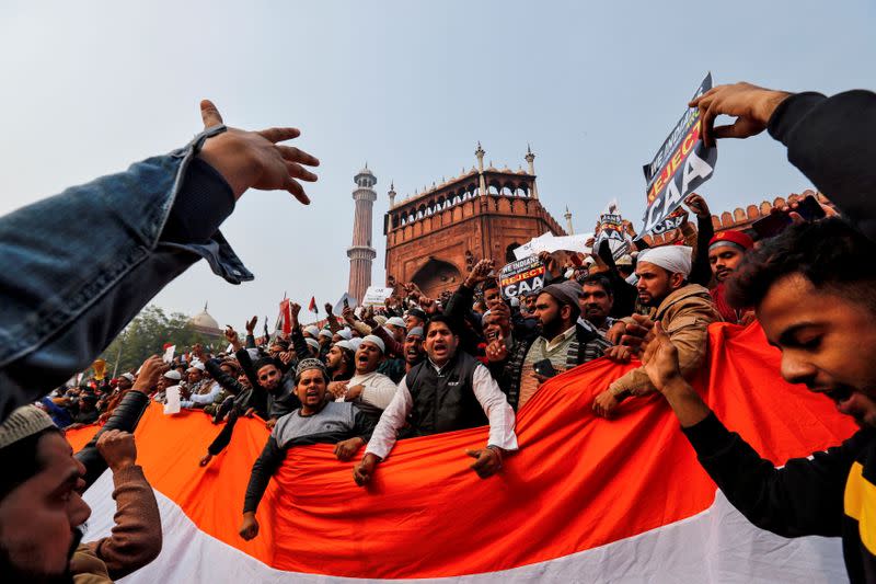 FILE PHOTO: Demonstrators hold the national flag of India as they attend a protest against a new citizenship law, after Friday prayers at Jama Masjid in the old quarters of Delhi