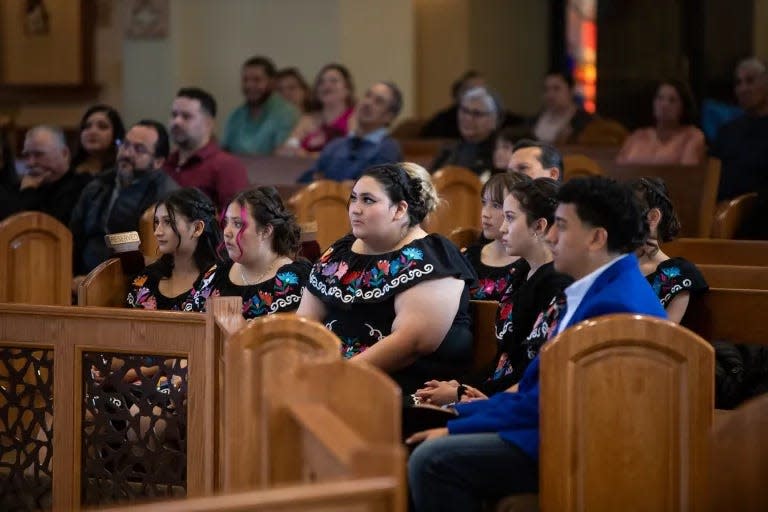 Karina’s quinceañera court, dressed in traditional embroidered dresses, listen to Bishop Mark Seitz during the celebration of Mass at St. Frances Xavier Cabrini Church.