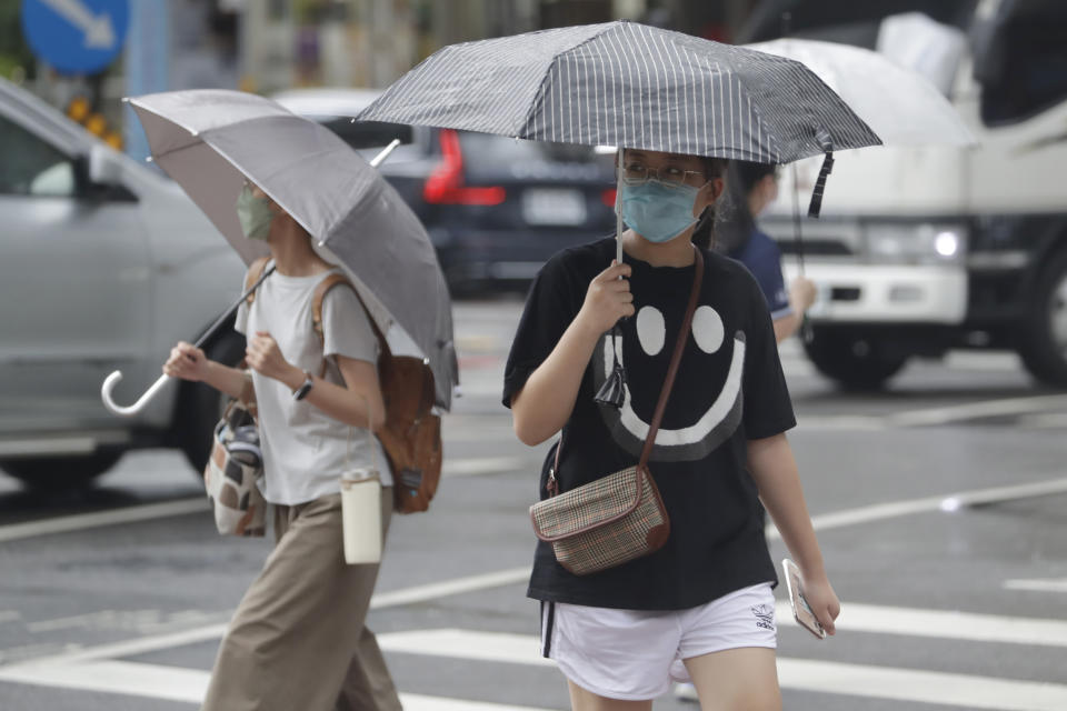 People walk in a rain ahead of the approaching Typhoon Hinnamnor in Taipei, Taiwan, Saturday, Sept. 3, 2022. (AP Photo/Chiang Ying-ying)