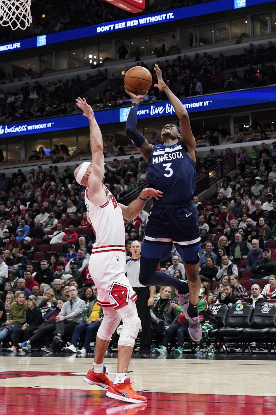 Minnesota Timberwolves forward Jaden McDaniels, right, drives to the basket against Chicago Bulls guard Alex Caruso during the first half of an NBA basketball game in Chicago, Friday, March 17, 2023. (AP Photo/Nam Y. Huh)