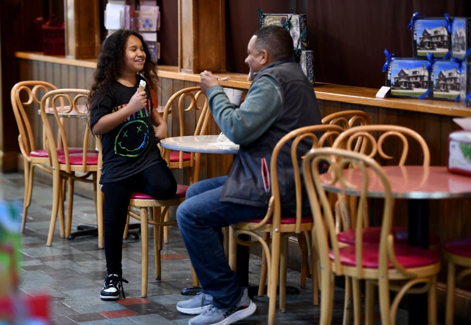 Niaya Rhone, 8, enjoys ice cream with her father, Trevor, at Hebert's Candy Mansion. She had mint chocolate chip and he had purple cow.