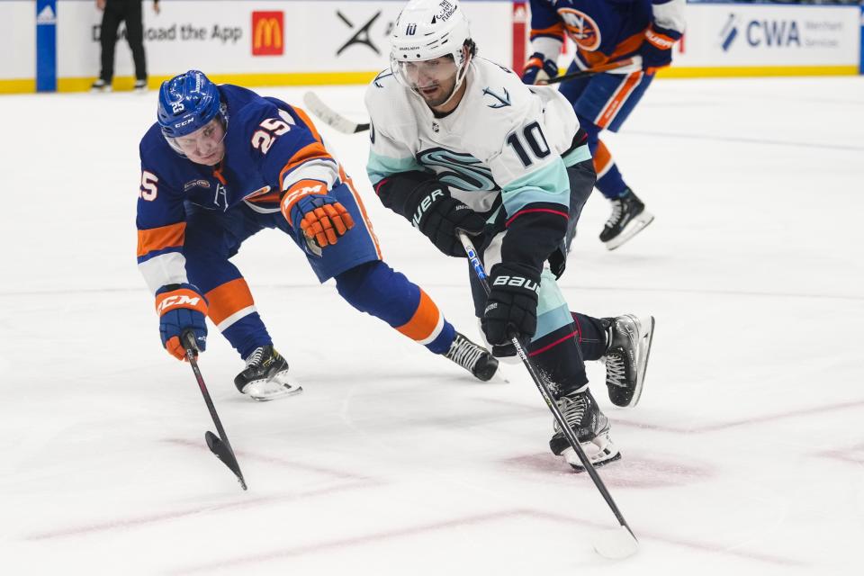 New York Islanders' Sebastian Aho (25) fights for control of the puck with Seattle Kraken's Matty Beniers (10) during the third period of an NHL hockey game Tuesday, Feb. 7, 2023, in Elmont, N.Y. The Islanders won 4-0. (AP Photo/Frank Franklin II)