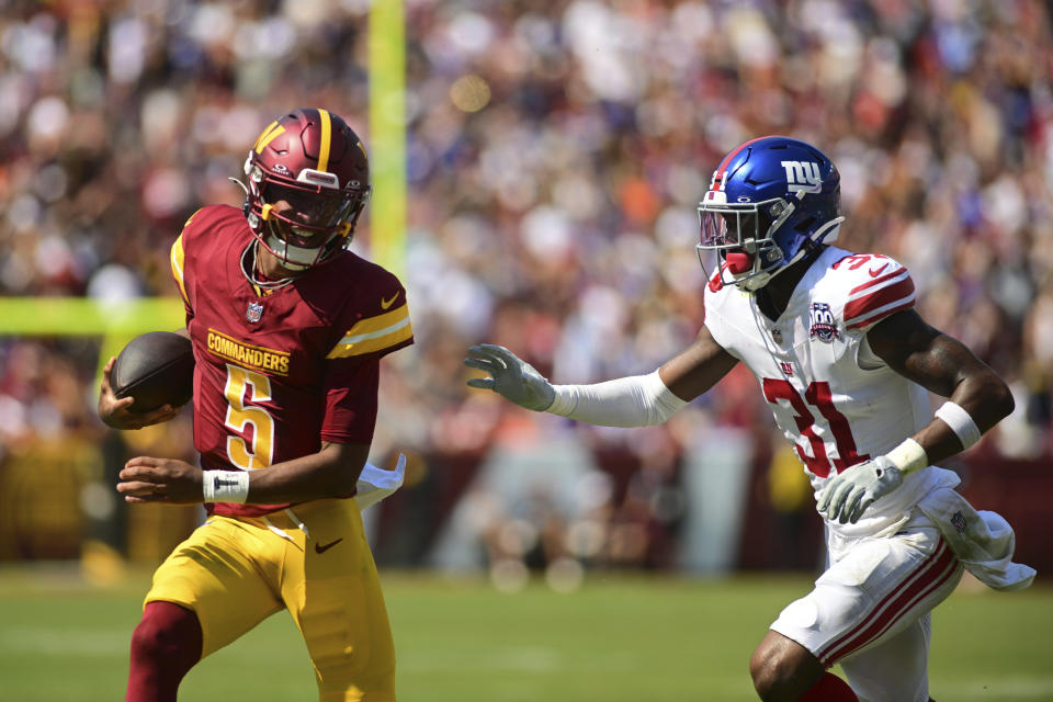 Washington Commanders quarterback Jayden Daniels (5) runs past New York Giants safety Tyler Nubin (31) during the first half of an NFL football game in Landover, Md., Sunday, Sept. 15, 2024. (AP Photo/Steve Ruark)