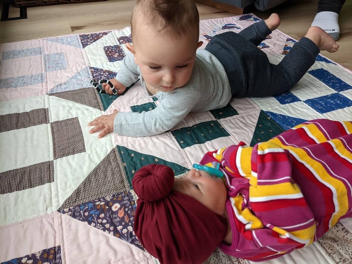 Big brother John Bogdan looks at his baby sister, Kate Juli, who was born on May 18, 2022, in Regina. Both children came into the world with the help of surrogates. (Submitted by Courtney Sastaunik - image credit)