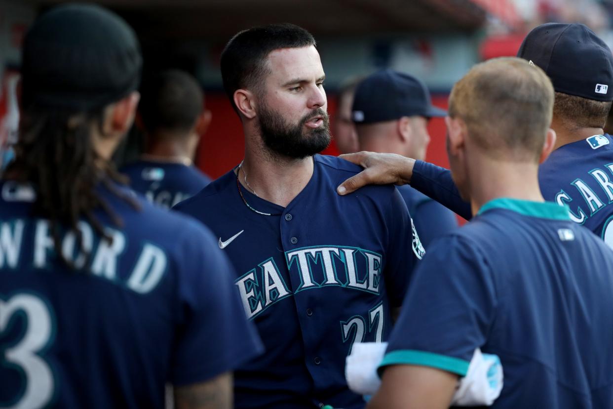 Seattle Mariners left fielder Jesse Winker (27) is congratulated by teammates after scoring a run in the third inning against the Los Angeles Angels at Angel Stadium on June 24.