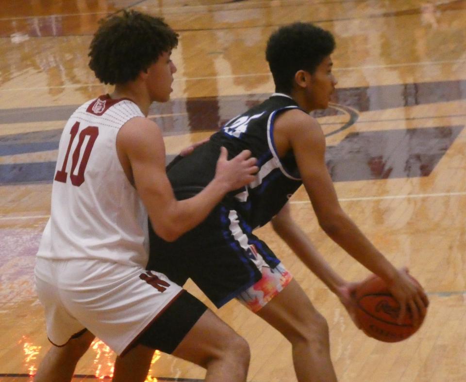 Zanesville sophomore Greyson Goines looks for a teammate from the post while being guarded by Newark sophomore Kalen Winbush at Jimmy Allen Gymnasium on Saturday, Dec. 3, 2022. The host Wildcats beat the Blue Devils 64-29, their 11th consecutive victory in the rivalry.