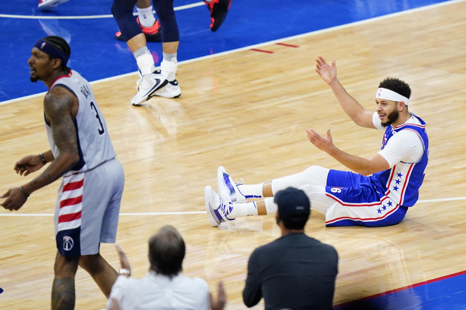 Philadelphia 76ers' Seth Curry, right, reacts after a foul by Washington Wizards' Bradley Beal, left, during the second half of Game 5 in a first-round NBA basketball playoff series, Wednesday, June 2, 2021, in Philadelphia. (AP Photo/Matt Slocum)