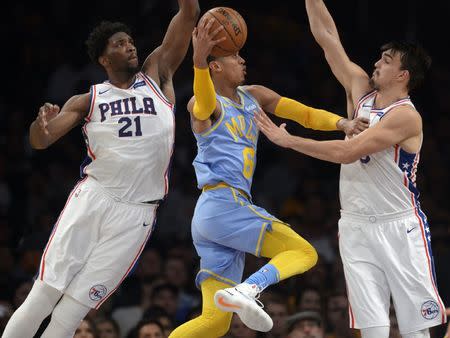 November 15, 2017; Los Angeles, CA, USA; Los Angeles Lakers guard Jordan Clarkson (6) moves to the basket against Philadelphia 76ers center Joel Embiid (21) and forward Dario Saric (9) during the first half at Staples Center. Gary A. Vasquez-USA TODAY Sports