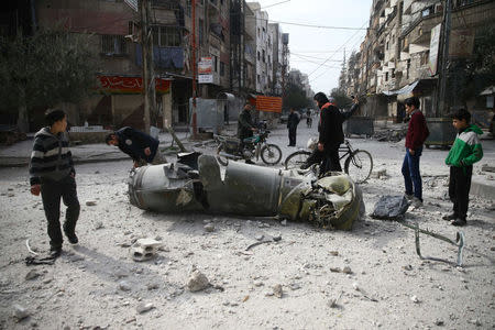 People inspect missile remains in the besieged town of Douma, in eastern Ghouta, in Damascus, Syria, February 23, 2018. REUTERS/Bassam Khabieh