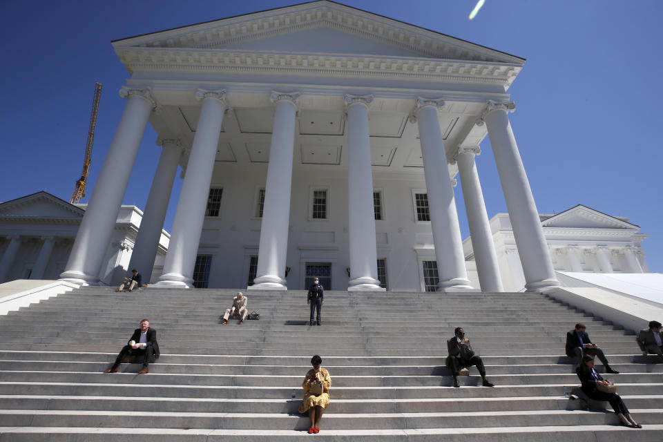 FILE - House of Delegates members eat boxed lunches on the steps of the Virginia Capitol in Richmond, Va., April 22, 2020. Dueling Virginia legislative proposals backed by differing gambling companies would open the door for an expansion of slots-like betting machines in businesses like truck stops, restaurants and convenience stores around the state. (Bob Brown/Richmond Times-Dispatch via AP, Pool, File)