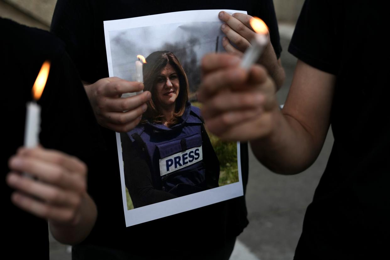 Protesters hold candles and a photo of slain Al Jazeera journalist Shireen Abu Akleh in Haifa, Israel, Wednesday, May 11, 2022.