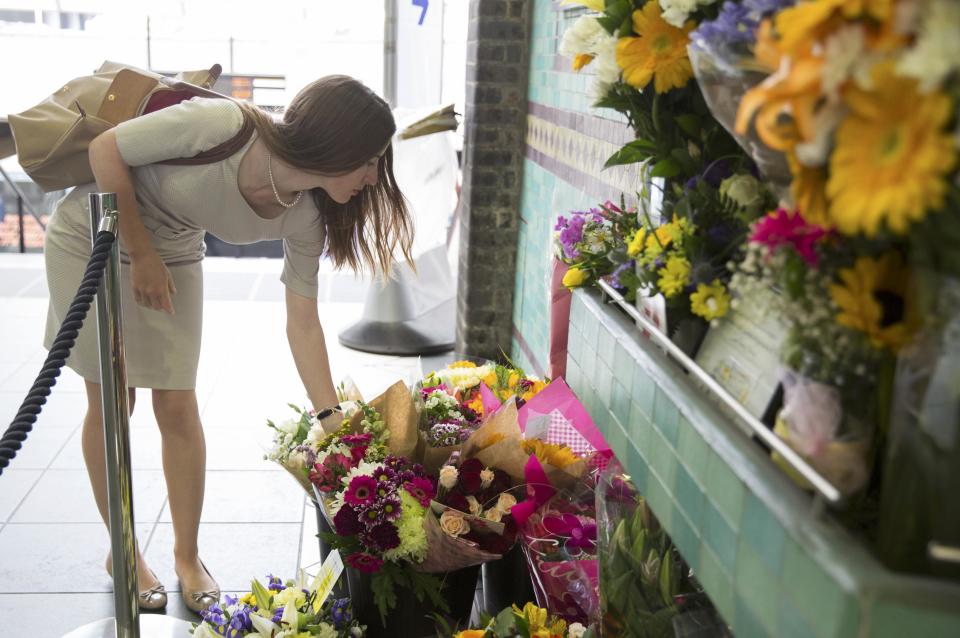 A woman places a floral tribute for victims of the July 7, 2005 London bombings, at Aldgate Station in London, Britain July 7, 2015. Britain fell silent on Tuesday to commemorate the 10th anniversary of attacks targeting London public transport which killed 56 people, the first suicide bombings by Islamist militants in western Europe. (REUTERS/Neil Hall)