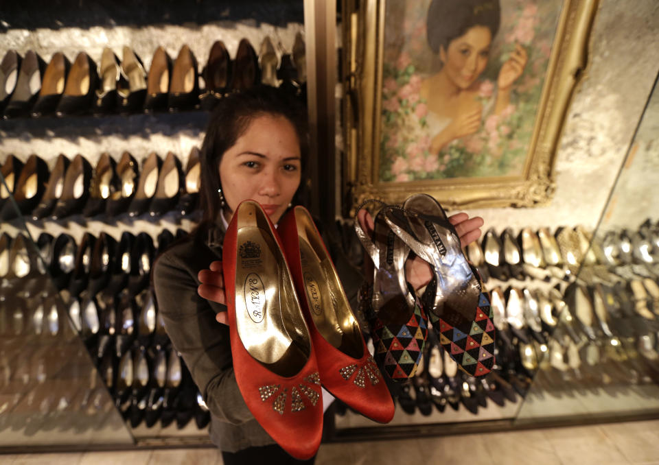 Jane Ballesteros, the curator of Marikina Museum where more than seven hundred pairs of shoes of former Philippine First Lady Imelda Marcos are housed, holds a pair of Marcos' shoes on Tuesday Sept. 25, 2012 at Marikina city east of Manila, Philippines. At the National Museum in Manila, termites, storms and government neglect have damaged hundreds of pieces of the late strongman Ferdinand Marcos' "barongs" as well as that of flamboyant Imelda Marcos' legendary stash of shoes, expensive gowns, and other vanity possessions which were left to oblivion after she and dictator husband were driven to U.S. exile by a 1986 popular revolt. (AP Photo/Bullit Marquez)