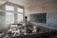 <p>Aal Okab School, Saada City, Yemen, April 24, 2017: A student at the Aal Okab school stands in the ruins of one of his former classrooms, which was destroyed during the conflict in June 2015. Students now attend lesson in UNICEF tents nearby. (Photograph by Giles Clarke for UN OCHA/Getty Images) </p>