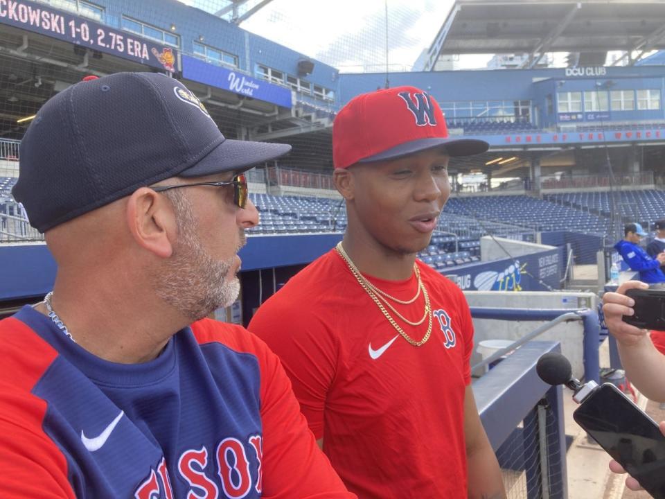 Brayan Bello, right, the top pitching prospect in the Boston system, speaks to the media alongside Worcester bench coach Jose David Flores.