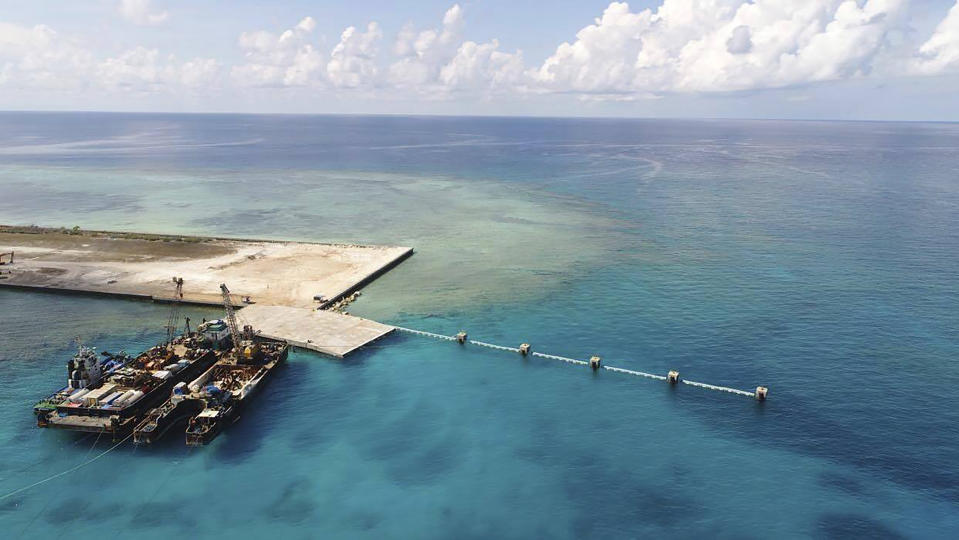 In this handout photo provided by the Department of National Defense PAS, ships carrying construction materials are docked at the newly built beach ramp at the Philippine-claimed island of Pag-asa, also known as Thitu, in the disputed South China Sea on Tuesday June 9, 2020. The Philippine defense chief and top military officials flew to a disputed island in the South China Sea Tuesday to inaugurate a beach ramp built to allow the "full-blast" development of the far-flung territory but would likely infuriate China. (Department of National Defense PAS via AP)