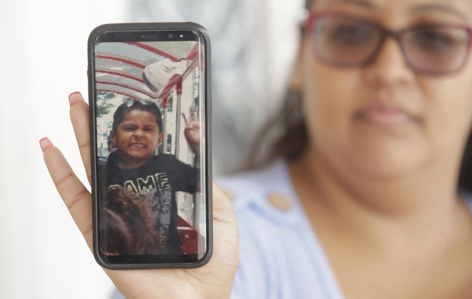 Josephine Guicho holds her phone showing a photo of her 6-year-old nephew Stephen Romero in San Jose, Calif., Monday, July 29, 2019. Romero is one of three young people who died when a gunman opened fire at a popular California food festival this past weekend. (AP Photo/Jeff Chiu)