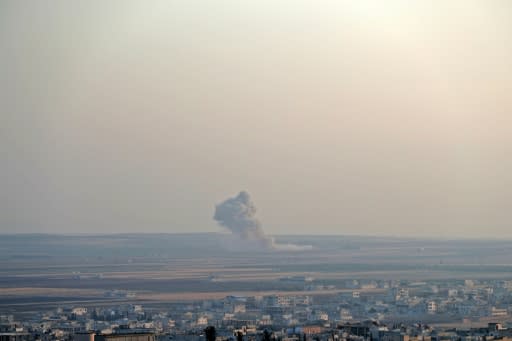 Smoke billowing above buildings during a reported air strike by pro-regime forces on Khan Sheikhun in the south of Idlib province on Monday