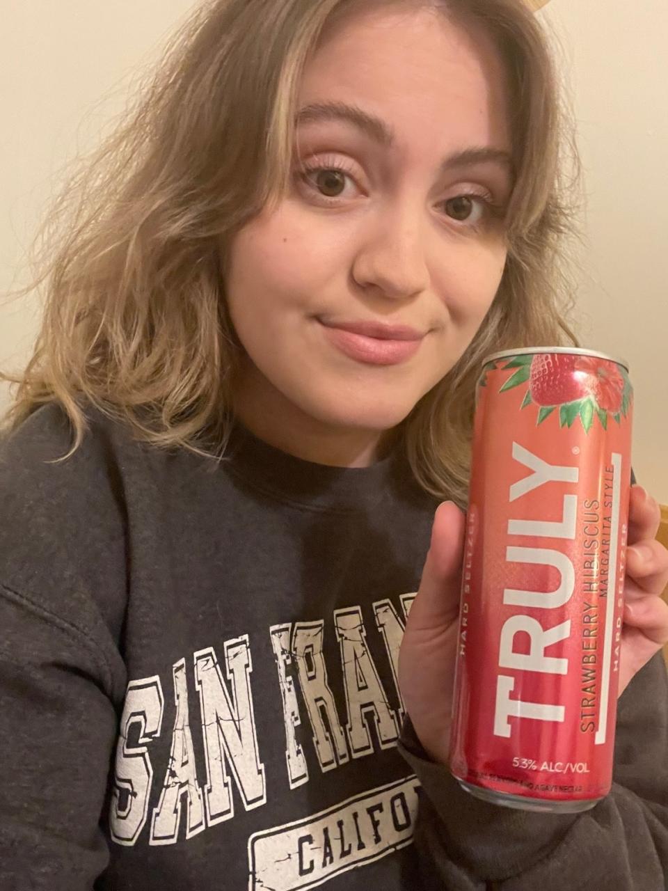 woman holding a strawberry hibiscus margarita seltzer