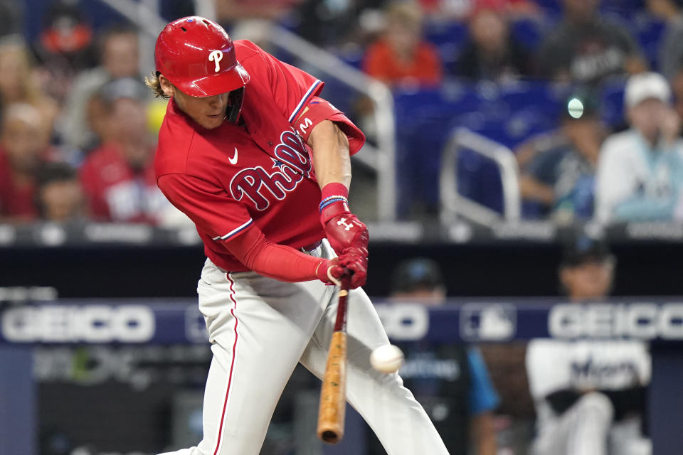 Philadelphia Phillies' Alec Bohm hits a sacrifice fly to score Rhys Hoskins during the first inning of a baseball game against the Miami Marlins, Saturday, April 16, 2022, in Miami. (AP Photo/Lynne Sladky)