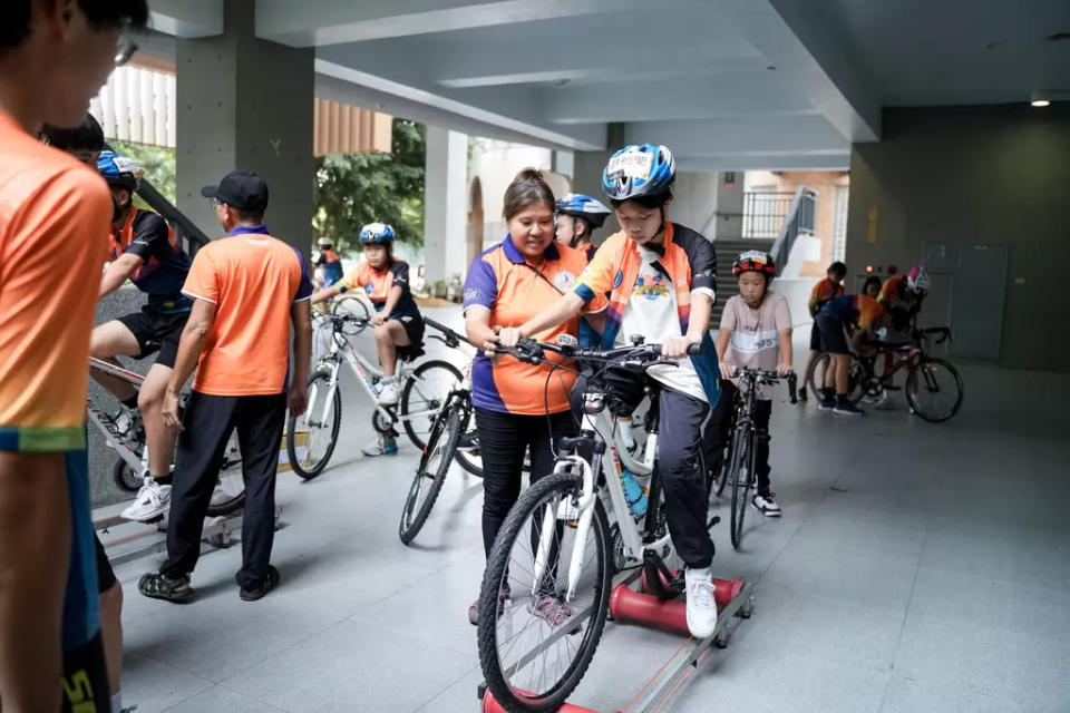 隊輔協助學員在自行車洞筒訓練台上練習 。官方提供