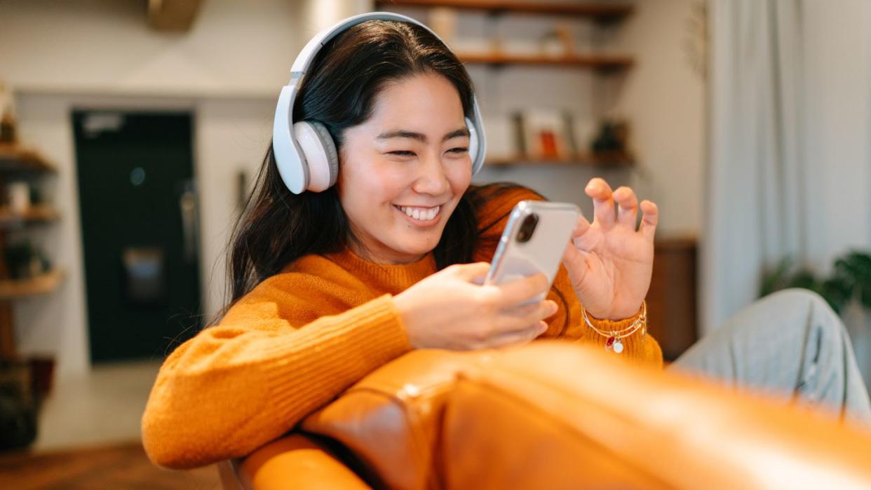 young woman listening to her headphones at home