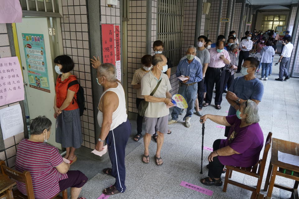 高雄市長補選今登場，民眾戴口罩在外等候投票。   圖：張良一/攝