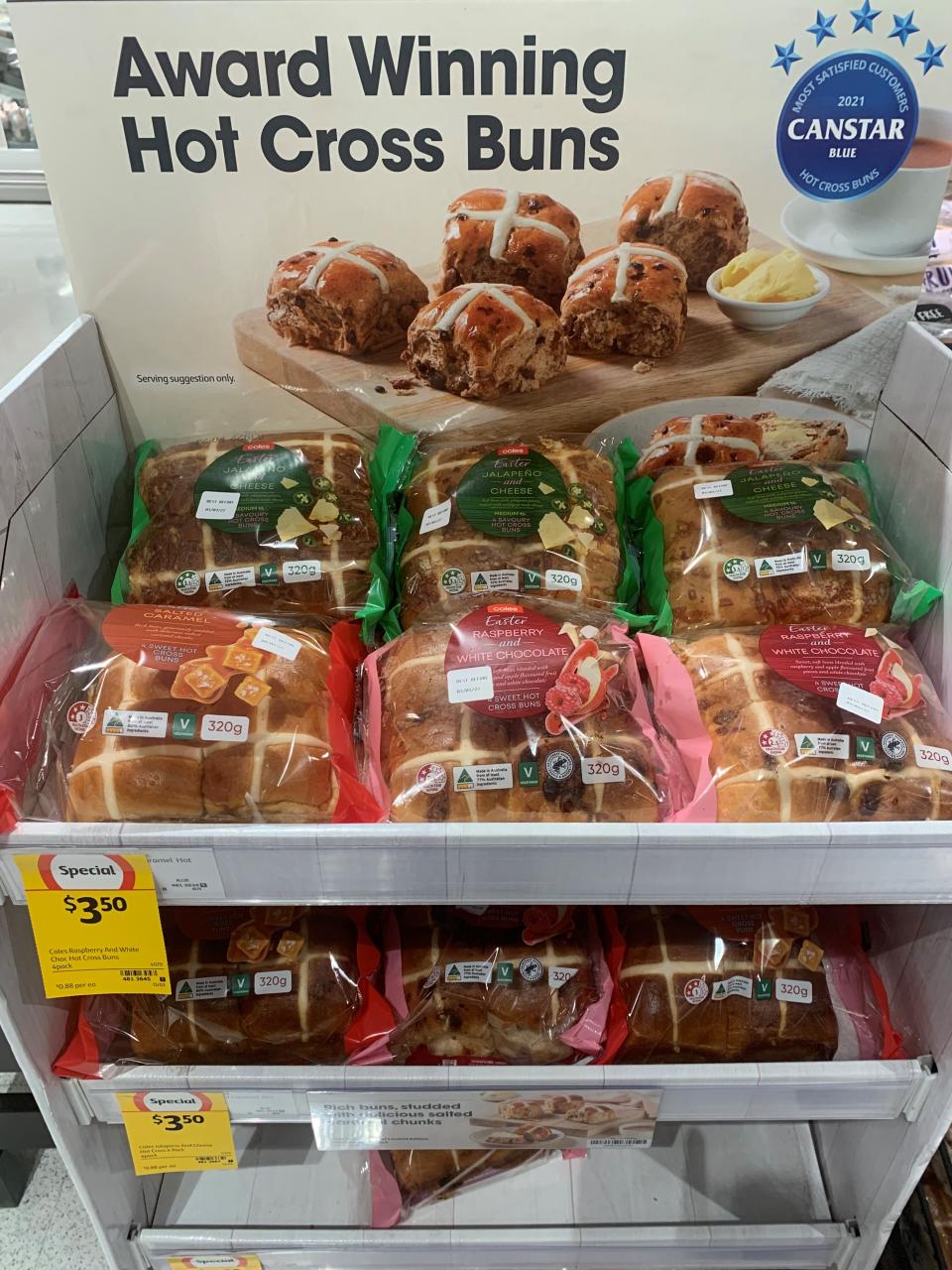 White chocolate and raspberry, salted caramel and jalapeño and cheese hot cross buns on the stands in a Coles supermarket