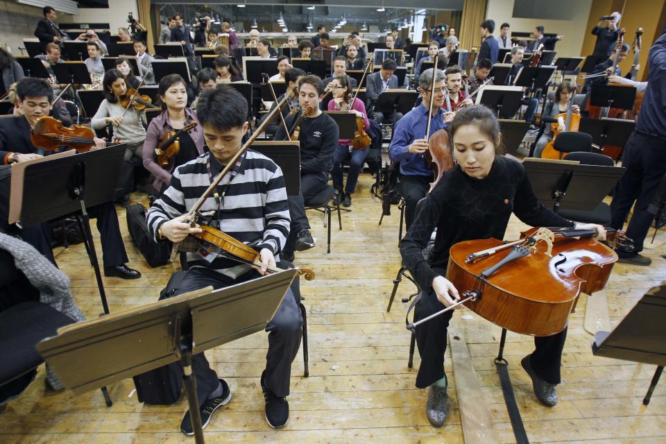 Two members of North Korea's Unhasu Orchestra prepare their instruments as they take part in a rehearsal with the Radio France Philharmonic Orchestra in Paris, Tuesday, March 13, 2012. Musicians from the Unhasu Orchestra will perform a piece together with Radio France Philharmonic Orchestra, directed by South Korean conductor Chung Myung-whun, in Paris, Wednesday, March 14. (AP Photo/Remy de la Mauviniere)