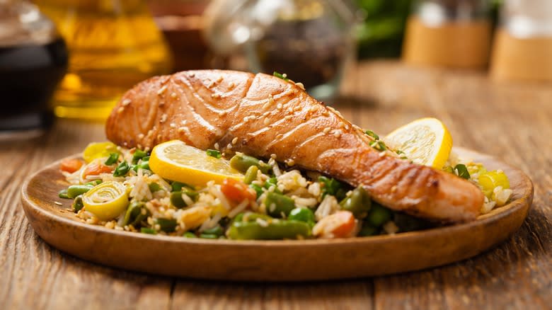 A salmon filet served over rice and vegetables