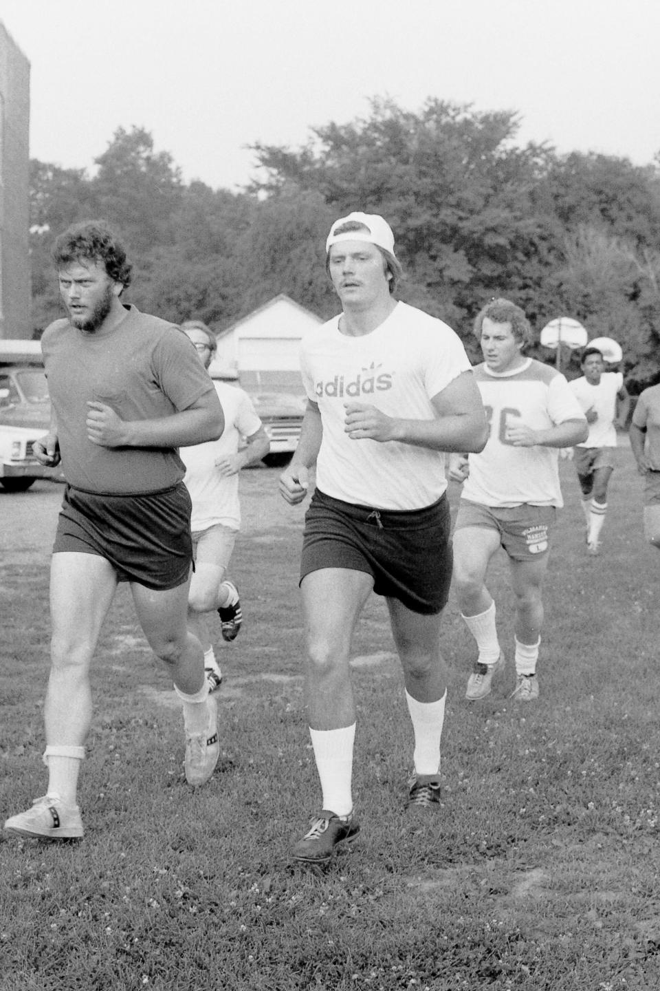 Chris Olsen of Garfield, right, leads his Boonton Bears semipro football teammates in a practice jog at the field in Boonton, N.J., on July 20, 1976.