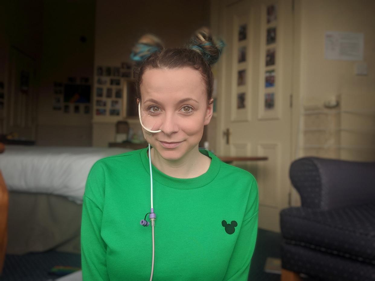 Eating disorder sufferer Faye Bingham wearing green jumper and smiling with feeding tube